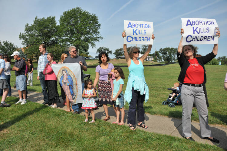 People hold pro-life signs in front of Planned Parenthood in Bettendorf, Iowa, in 2015. (CNS photo/Lindsay Steele, The Catholic Messenger) 