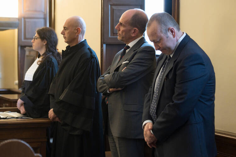 Giuseppe Profiti, second from right, former president of Bambino Gesu hospital in Rome, and Massimo Spina, right, former treasurer of the hospital, are pictured during their sentencing at the Vatican court Oct. 14. Profiti was found guilty of illicit appropriation and use of funds belonging to the Bambino Gesu Foundation. He was given a suspended sentence of one year in jail and a 5,000 Euro fine. Spina was absolved of the charges. (CNS photo/L'Osservatore Romano) 