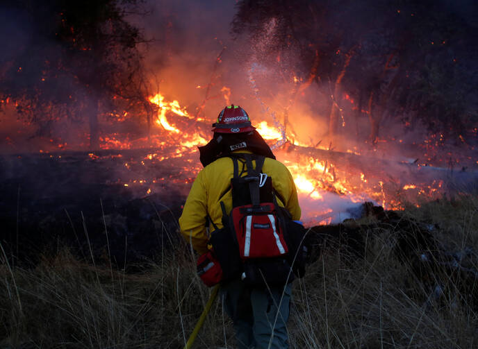 A firefighter battles a wildfire on Oct. 14 near Santa Rosa, Calif. The fire claimed the lives of more than 40 people. (CNS photo/Jim Urquhart, Reuters)