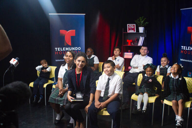 Galveston-Houston Catholic school students smile for a photo before a live video chat with Pope Francis at Telemundo Houston Oct. 26. In a video chat with young children from Texas and Puerto Rico, the pope said there are no easy answers to the suffering and destruction wrought by hurricanes. (CNS photo/James Ramos, Texas Catholic Herald) 