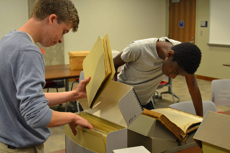 Gonzaga College High School students look through the archives in late June at Georgetown University in Washington. Gonzaga history teacher Ed Donnellan and six students searched through the archives to unearth any ties to slavery at the Jesuit-run high school. (CNS photo/courtesy Gonzaga College High School)