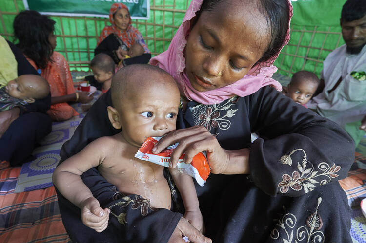 A woman from Myanmar feeds her child in a U.N. clinic for severely malnourished Rohingya children Oct. 28 in the Balukhali Refugee Camp near Cox's Bazar, Bangladesh. More than 600,000 Rohingya have fled government-sanctioned violence in Myanmar for safety in Bangladesh. (CNS photo/Paul Jeffrey)