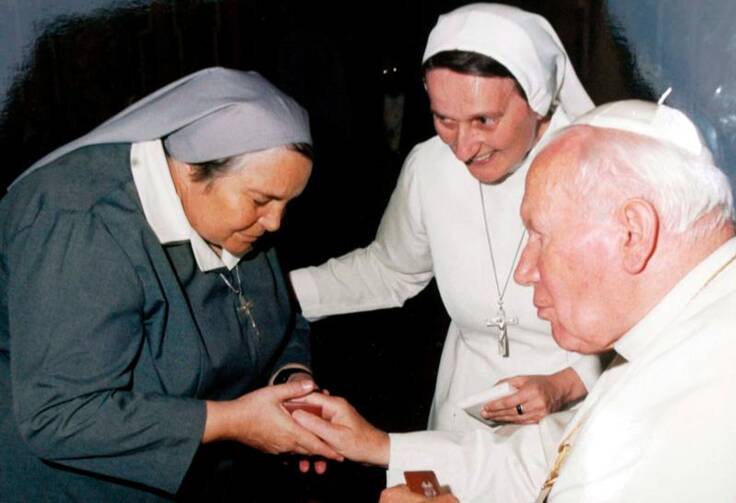 St. John Paul II presents a gift to Consolata Sister Leonella Sgorbati in Milan, Italy, in this undated photo. Sister Leonella and her bodyguard were gunned down in September 2006 as they left the children's hospital where she worked in Mogadishu, Somalia. (CNS photo/PH Emmevi, EPA)