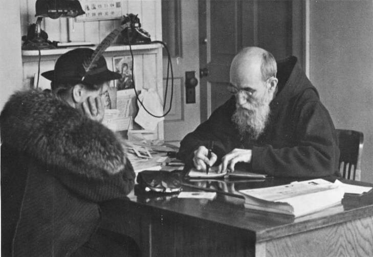 Blessed Solanus Casey, who was beautified during a Mass on Nov. 18 at Ford Field in Detroit, records a note from a woman who visited him at St. Bonaventure Monastery in Detroit in 1941. The Capuchin Franciscan friar kept dozens of notebooks filled with prayer requests and favors from the thousands who visited him each year. (CNS photo/Archdiocese of Detroit)