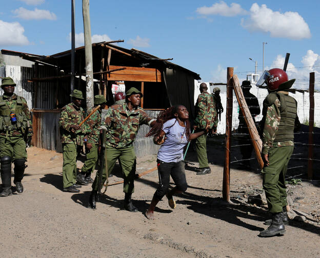 A police officer pushes a supporter of the Kenyan National Super Alliance during clashes Nov. 28 in Nairobi. Kenyan police fired tear gas and clashed with both ruling party and opposition supporters as President Uhuru Kenyatta was sworn in for a second term. Two disputed polls left the nation deeply divided. (CNS photo/Thomas Mukoya, Reuters)