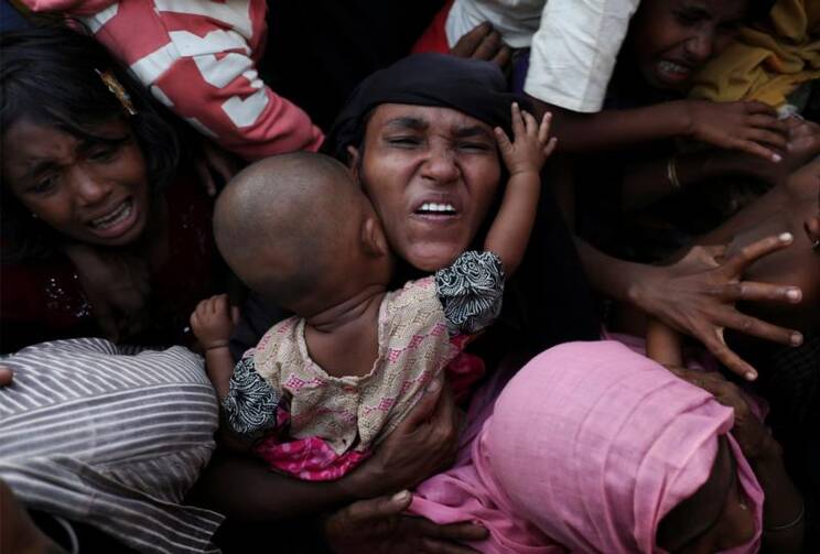 A Rohingya woman holds her infant as she scuffles to receive relief aid Nov. 28 in the Kutupalong refugee camp near Cox's Bazar, Bangladesh. (CNS photo/Susana Vera, Reuters)