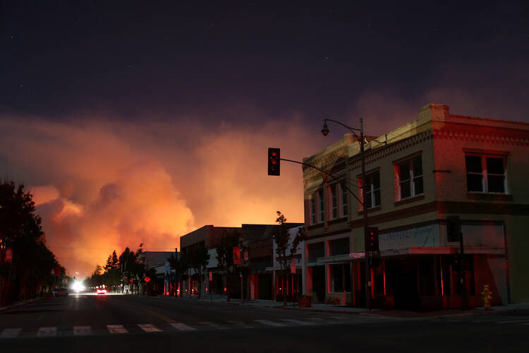 Burned cars are seen on a piece of property Dec. 5 during a wildfire near Santa Paula, Calif. Pushed by powerful Santa Ana winds, the fire spread with explosive speed to 31,000 acres in Southern California's Ventura County, forcing thousands to evacuate in the dark. (CNS photo/David McNew, Reuters)