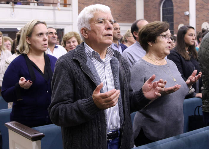 Worshippers recite the Lord's Prayer during Mass at Corpus Christi Church in Mineola, N.Y., on Oct. 13. (CNS photo/Gregory A. Shemitz, Long Island Catholic)
