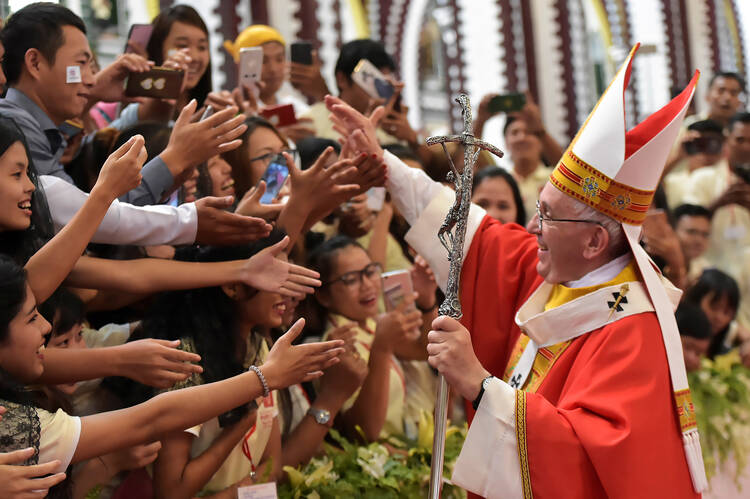 Pope Francis greets young people after celebrating Mass with youths Nov. 30 at St. Mary's Cathedral in Yangon, Myanmar. Foreign trips, a focus on the rights and needs of migrants and refugees and a Synod of Bishops dedicated to young people all are on the 2018 calendar for Pope Francis. (CNS photo/L'Osservatore Romano via Reuters) 