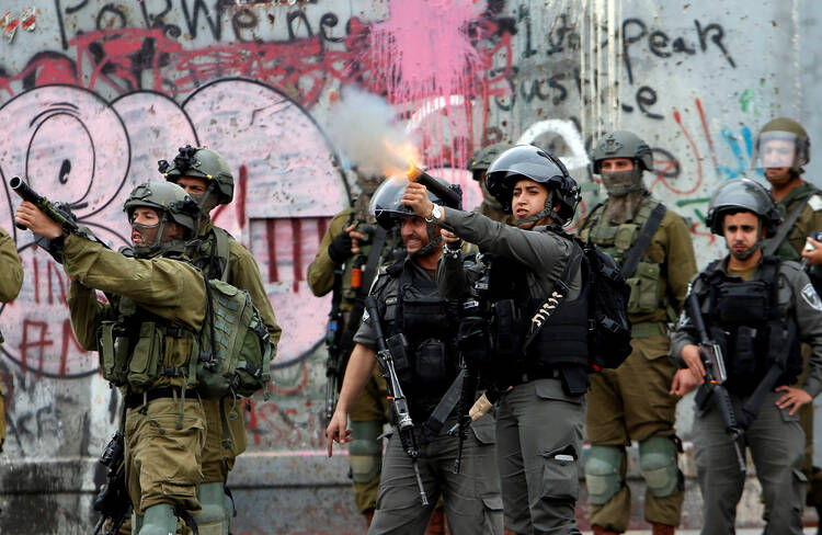 Israeli forces fire toward Palestinians near Ramallah, West Bank, during a Dec. 20 protest against U.S. President Donald Trump's decision to recognize Jerusalem as the capital of Israel. (CNS photo/Mussa Qawasma Reuters)