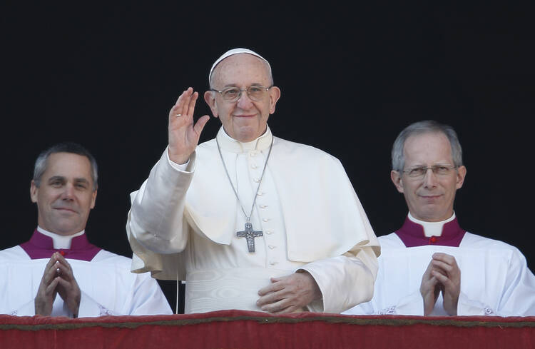 Pope Francis waves as he arrives to deliver his Christmas message and blessing "urbi et orbi" (to the city and the world) from the central balcony of St. Peter's Basilica at the Vatican on Dec. 25. (CNS photo/Paul Haring) 