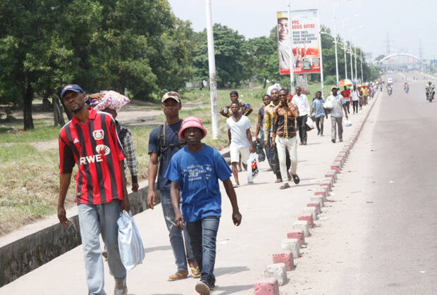 People walk as traffic is blocked by security forces Dec. 31 in Kinshasa, Congo. Church leaders in Congo have expressed "profound shock" after security forces fired on Catholics protesting rule by President Joseph Kabila, leaving at least eight dead. (CNS photo/Kenny Katombe, Reuters)