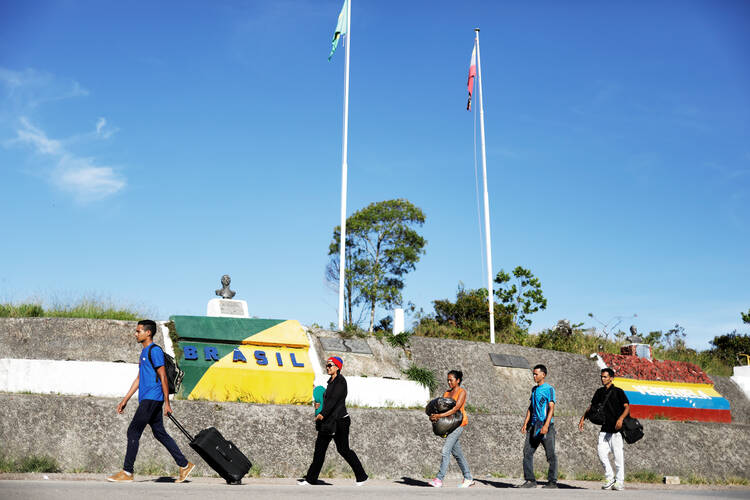 Venezuelan migrants walk across the border from Venezuela into the Brazilian city of Pacaraima. (CNS photo/Nacho Doce)