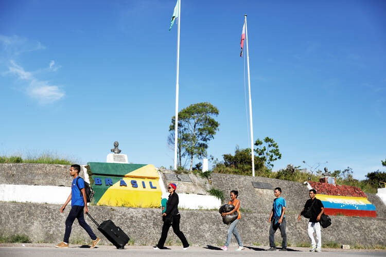 Venezuelan migrants walk across the border from Venezuela into the Brazilian city of Pacaraima. In his message for World Day of Migrants and Refugees Jan. 14, Pope Francis urged countries to welcome, protect and integrate foreigners who cross their borders. (CNS photo/Nacho Doce)