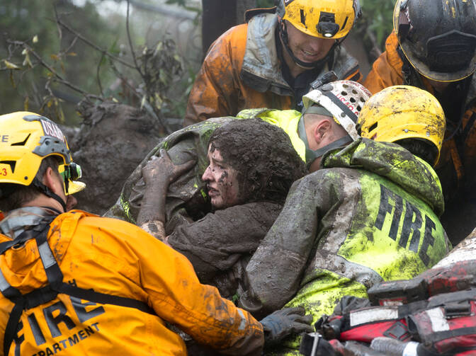 Emergency personnel carry a woman rescued from a collapsed house Jan. 9 after a mudslide in Montecito, Calif. Weeks after devastating fires tore through Southern California, heavy rains sent mudslides rolling down hillsides in Santa Barbara County, leaving at least 13 people dead and dozens injured. (CNS photo/Kenneth Song, Santa Barbara News-Press via Reuters)