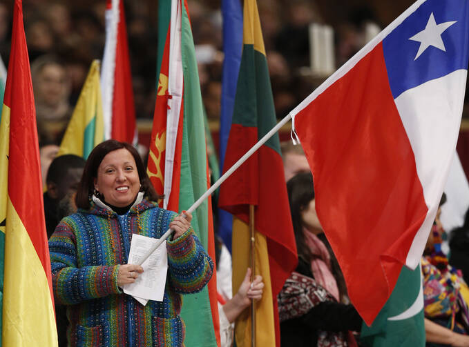 A woman holds Chile's flag as Pope Francis celebrates Mass marking the World Day of Migrants and Refugees in St. Peter's Basilica at the Vatican Jan. 14. The pope is scheduled to arrive in Santiago, Chile, Jan. 15. (CNS photo/Paul Haring)