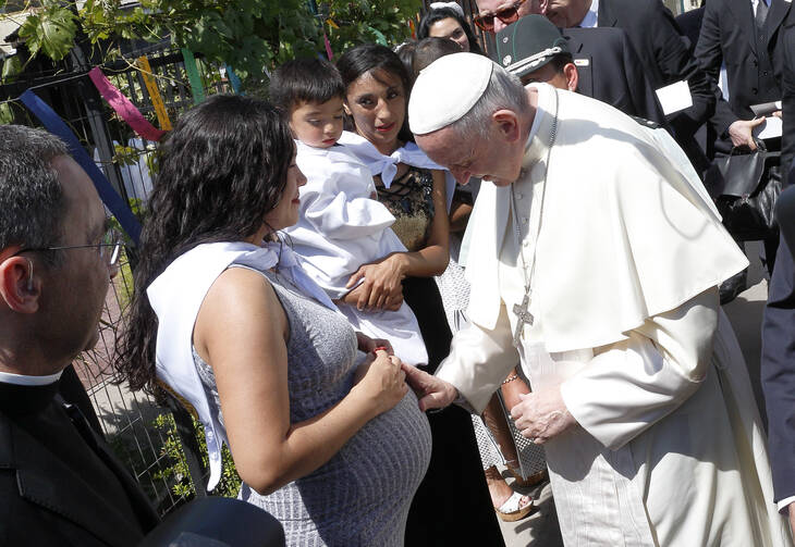 Pope Francis blesses a pregnant prisoner as he visits the women's prison center in Santiago, Chile, Jan. 16. (CNS photo/Paul Haring)
