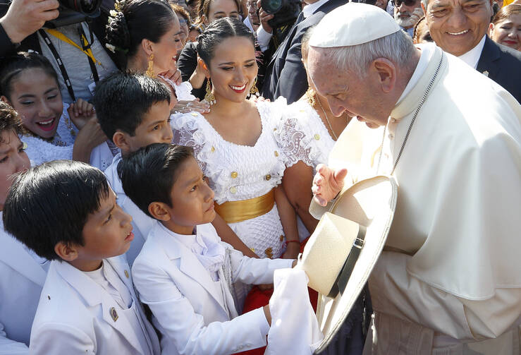 A boy presents a hat to Pope Francis upon his arrival at the international airport in Trujillo, Peru, Jan. 20. (CNS photo/Paul Haring) 