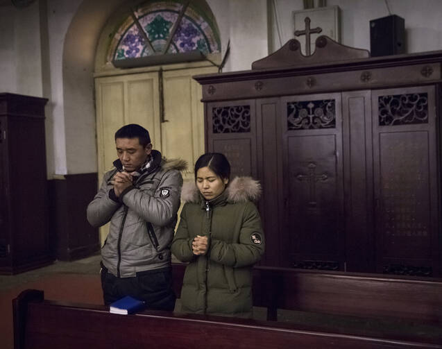 People pray during morning Mass Jan. 30 in Cathedral of the Immaculate Conception in Beijing. (CNS photo/Roman Pilipey, EPA)
