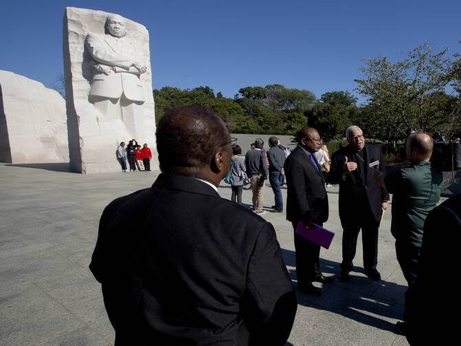 Bishop George V. Murry of Youngstown, Ohio, chair of the U.S. bishops' Ad Hoc Committee Against Racism, center right, conducts an interview near the Martin Luther King Jr. Memorial in Washington on Oct. 2, 2017. (CNS photo/Tyler Orsburn)