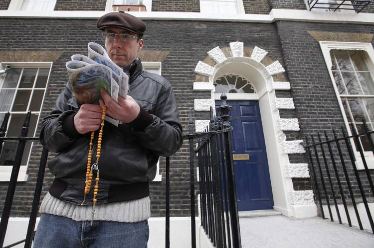 A pro-life activist holds a rosary stands outside an abortion clinic in 2012 in London. A prominent Catholic lawyer has expressed concern that local governments are considering exclusion zones around abortion clinics, with no proof anyone is harassing pregnant women. (CNS photo/Andrew Winning, Reuters)