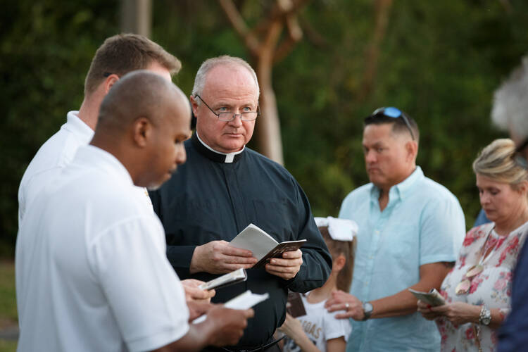 Father Ireneusz Ekiert, administrator of Mary Help of Christians Church in Parkland, Fla., leads parishioners during an outdoor Stations of the Cross service on Feb. 16 dedicated to the victims and survivors of the deadly mass shooting at nearby Marjory Stoneman Douglas High School. (CNS photo/Tom Tracy)