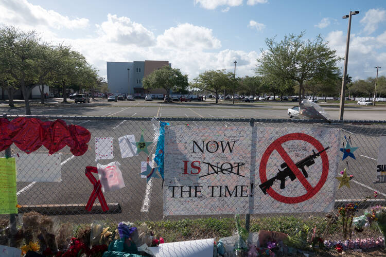 Messages hang on a fence as hundreds of students and parents arrive for campus orientation on Feb. 25 at Marjory Stoneman Douglas High School in Parkland, Fla. Attendance at the orientation was voluntary, but it was being held in anticipation of the school officially reopening on Feb. 28. (CNS photo/Angel Valentin, Reuters) 