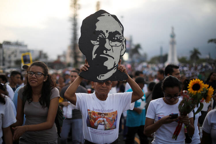 A man carries an image of Blessed Oscar Romero during a March 18 procession in San Salvador, El Salvador, to commemorate the 38th anniversary his murder. Pope Francis has cleared the way for the canonization of Blessed Romero, who was shot and killed March 24, 1980, as he celebrated Mass. (CNS photo/Jose Cabezas, Reuters)