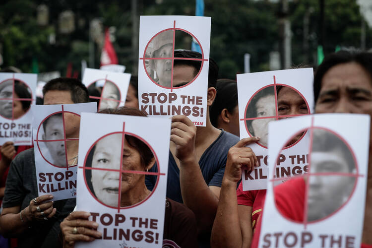 Philippine activists hold banners to mark International Human Rights Day in Manila Dec. 10, 2017. (CNS photo/Mark R. Cristino, EPA)