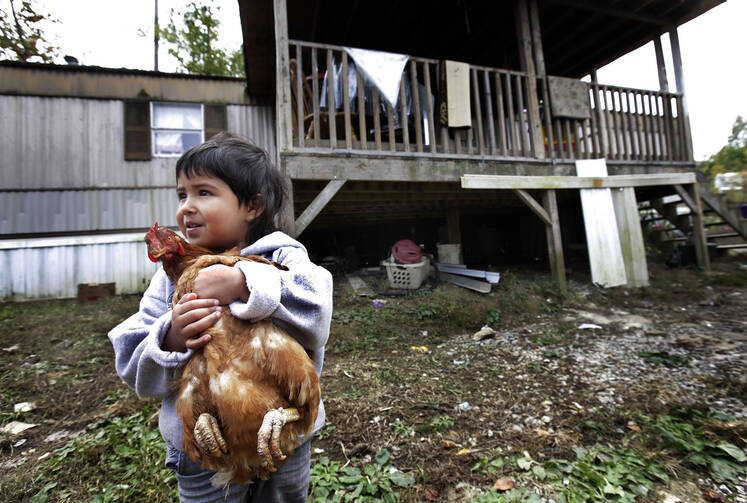 A boy holds a family chicken outside his home in Steele, Ala., in this 2013 file photo. (CNS photo/Karen Callaway, Catholic New World) 