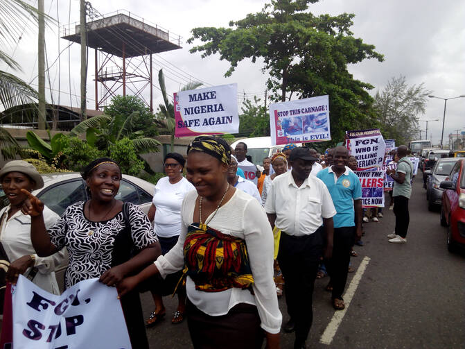 Nigerians carry placards during a May 22 protest in Lagos against the killing of innocent citizens, presumably by herdsmen, in some parts of the country. Catholics marched in various cities around the country. (CNS photo/Peter Dada)