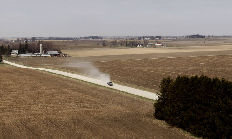 A truck travels along a dirt road near a grain farm in Hesper Township, Iowa. The 2018 farm bill was defeated on the floor of the House May 18. It could back for a second vote in late June, but Catholic and other rural life advocates see a need for improvements in the measure before then. (CNS photo/Bob Roller)