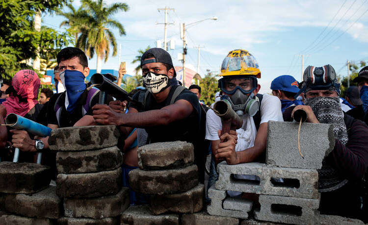 Demonstrators in Managua, Nicaragua, stand behind a barricade during clashes with police May 30. (CNS photo/Oswaldo Rivas, Reuters) 
