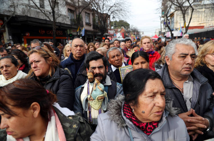 Worshippers pray during a Mass in honor of of St. Cajetan, the patron saint of labor and bread, during feast day celebrations for the saint on Aug. 7, 2018, outside St. Cayetano Church in Buenos Aires, Argentina. (CNS photo/Marcos Brindicci, Reuters)