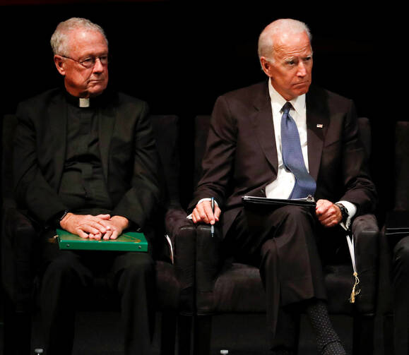 Edward Reese, S.J., president of St. Ignatius College Prep in San Francisco, and former Vice President Joe Biden, listen to speakers during a memorial service for U.S. Sen. John McCain, R-Ariz., at North Phoenix Baptist Church. (CNS photo/Matt York, Pool via Reuters)