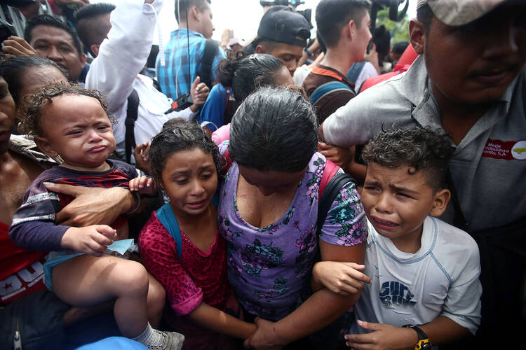 Honduran migrants trying to reach the United States struggle at a border checkpoint on Oct. 19 in Ciudad Hidalgo, Mexico. (CNS photo/Edgard Garrido, Reuters)