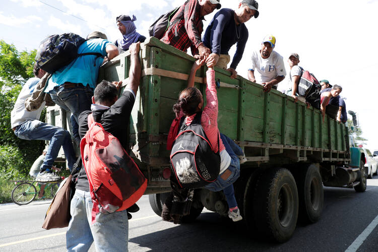 Honduran migrants climb on a truck Oct. 23 in Chiquimula, Guatemala, as they travel with other Central Americans in a caravan heading to the United States. (CNS photo/Luis Echeverria, Reuters)