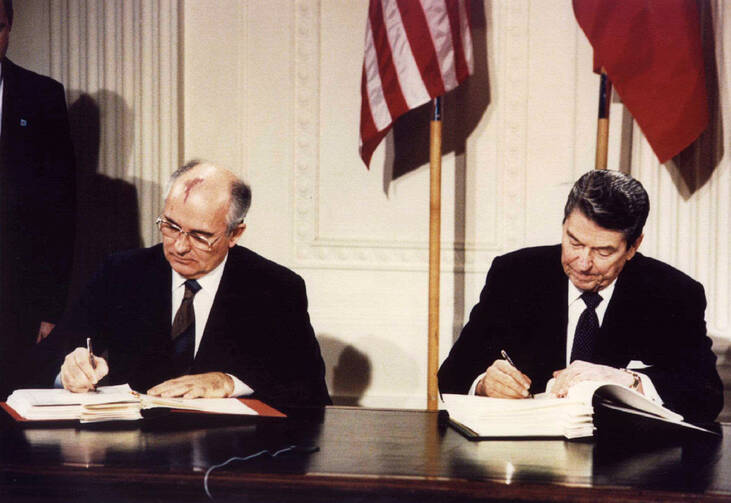 Soviet President Mikhail Gorbachev and U.S. President Ronald Reagan sign the Intermediate-Range Nuclear Forces treaty at the White House in Washington Dec. 8 1987. (CNS photo/Reuters)