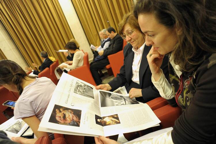 Looking at Women Church World, a monthly women's magazine insert in the Vatican's L'Osservatore Romano newspaper. (CNS photo/L'Osservatore Romano via Reuters) 