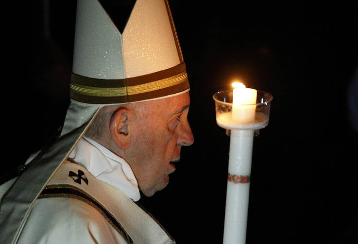 Pope Francis carries a candle in procession as he arrives to celebrate the Easter Vigil in St. Peter's Basilica at the Vatican April 20, 2019. (CNS photo/Paul Haring) 