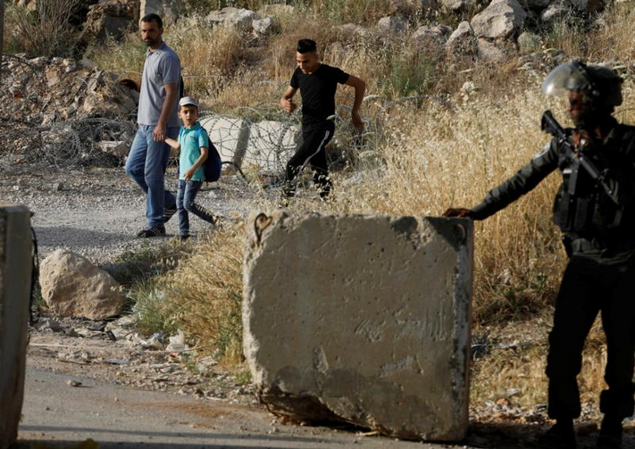 image: An Israeli border policeman stands guard not far from Ramallah, West Bank, May 17, 2019, as Palestinians make their way to attend Friday prayer at al-Aqsa mosque in Jerusalem's Old City. (CNS photo/Raneen Sawafta, Reuters)