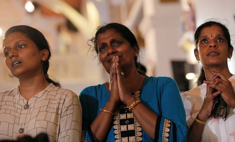 Family members of victims react while praying during the reopening ceremony of St. Anthony's Shrine in Colombo, Sri Lanka, June 12, 2019, months after it was closed because of an Easter bombing. (CNS photo/Dinuka Liyanawatte, Reuters) 