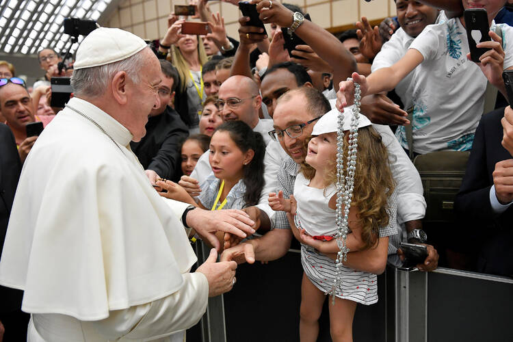 Pope Francis greets pilgrims as he arrives for his general audience in Paul VI hall at the Vatican on Aug. 7. (CNS photo/Vatican Media via Reuters) 