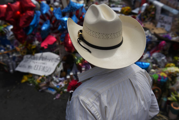 A man pays his respects Aug. 8, 2019, at a memorial five days after a mass shooting Aug. 3 at a Walmart store in El Paso, Texas. (CNS photo/Callaghan O'Hare, Reuters) 