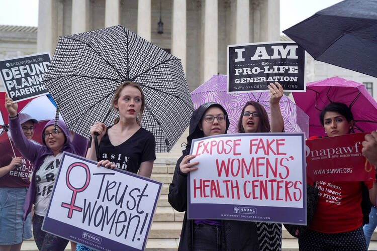 A woman who supports abortion access stands alongside pro-life supporters during a rally outside the U.S. Supreme Court in Washington in June 2018. (CNS photo/Toya Sarno Jordan, Reuters)