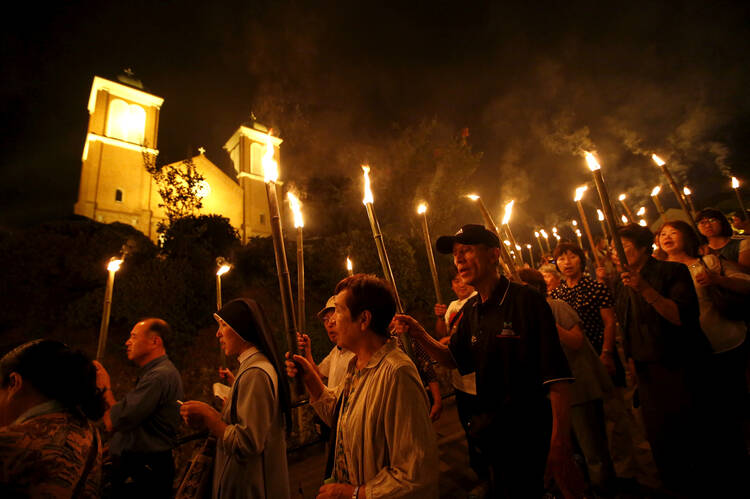 Catholics holding torches leave Urakami Cathedral in Nagasaki, Japan, Aug. 9, 2015, after praying for victims of the 1945 atomic bombing. Pope Francis will finally fulfill his desire to be a missionary to Japan when he visits the country, as well as Thailand, Nov. 20-26, 2019, the Vatican announced Sept. 13. (CNS photo/Toru Hanai, Reuters)
