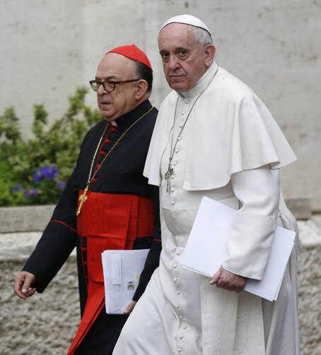 Pope Francis and Cardinal Raymundo Damasceno Assis of Aparecida, Brazil, walk to a meeting of cardinals in the synod hall at the Vatican Feb. 20, 2014. In a statement released by the Vatican Sept. 28, 2019, the pope named Cardinal Damasceno as pontifical commissioner of the Heralds of the Gospel and its religious branches for consecrated men and women. (CNS photo/Paul Haring) 