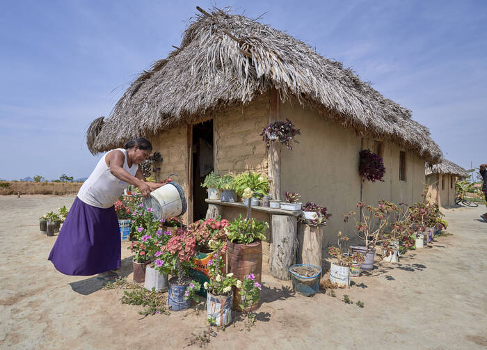 Celestina Fernandes da Silva, a Catholic activist, waters flowers in front of her home in the Wapishana indigenous village of Tabalascada, Brazil, on April 3, 2019. (CNS Photo/Paul Jeffrey) 