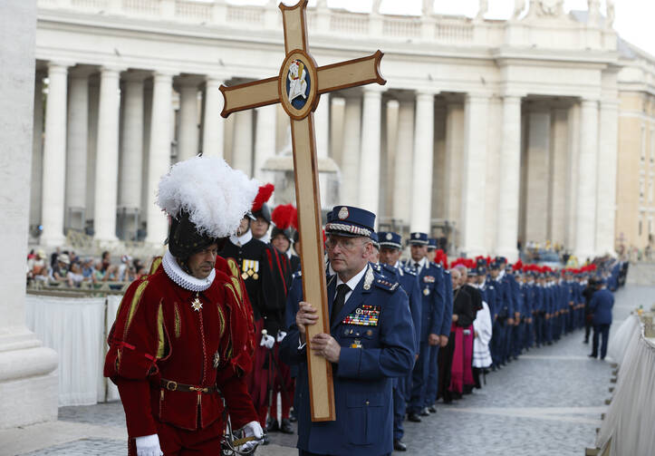 Domenico Giani, former chief of the Vatican police force, holds a cross as Vatican police officers and Swiss Guards process through St. Peter's Square in September 2016. Pope Francis appointed Gianluca Gauzzi Broccoletti, a cybersecurity expert, as the new head of the Vatican Security Services on Oct. 15. (CNS photo/Paul Haring) 