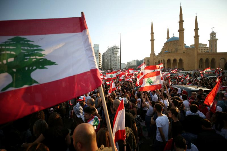 Image: Demonstrators near Al-Amin mosque in Beirut carry national flags during an anti-government protest Oct. 20, 2019. Fueled by economic insecurity and deteriorating living conditions, protests were sparked by government plans to impose new taxes. (CNS photo/Ali Hashisho, Reuters)